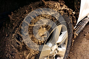 Dirty car wheel after an extreme ride. Traveling by SUV to places without asphalt. Close-up