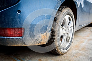 Dirty car wheel with swamp spray on the car