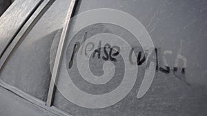 On a dirty car is written: & x22;Please wash me.& x22; Prank over the owner of a black car.