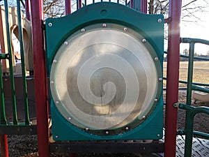 Dirty circular plastic window on play structure at playground