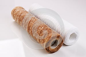 Dirty and clean water filters lie side by side on a white background