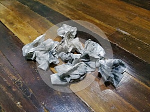 Dirty cloth-like crumpled wet wipes on wooden floor