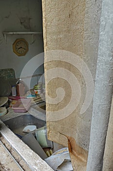 Dirty curtain and kitchen sink with unwashed dishes