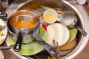 Dirty cutlery, dishes, plates and pans in a sink