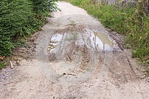 dirty dirt road with puddles and mud in countryside in Thailand