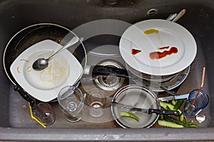 Dirty dishes and glasses in the sink.