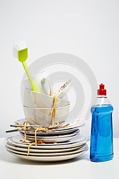 Dirty dishes pile needing washing up on white background