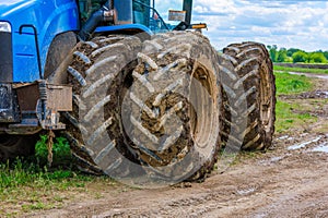 dirty double wheels of agriculture tractor at summer day