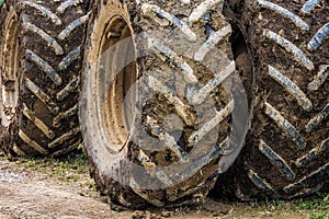 dirty double wheels of agriculture tractor at sunny day