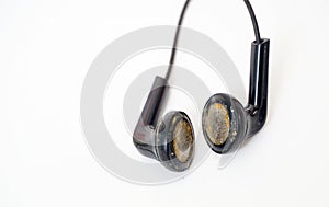 dirty and dusty used black ear buds  on white background