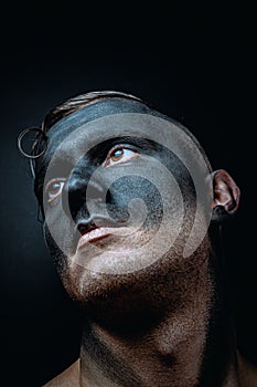 The dirty face of a working miner. Close-up portrait of a black face in soot. Stock photo