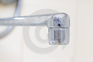 Dirty faucet aerator with limescale, calcified shower water tap with lime scale in bathroom, close up