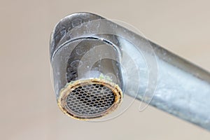 Dirty faucet aerator with limescale, calcified shower water tap with lime scale in bathroom, close up photo