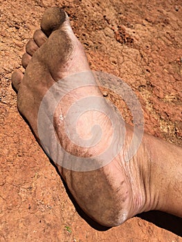 Dirty foot on red ground