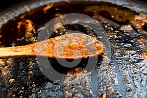 Dirty frying pan with a spoon