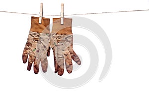 Dirty garden work gloves hanging on a clothesline