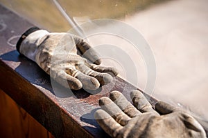 Dirty gardener\'s gloves close-up. Rubberized white gloves of a farmer in the soil after work