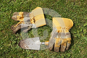 Dirty gardening gloves and trowel