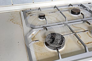Dirty gas stove cooking oil stains on gas stove in kitchen.An Unclean and Dirty Kitchen used For Cooking Food and photo