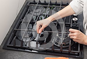 dirty gas stove top. woman preparing to clean kitchen