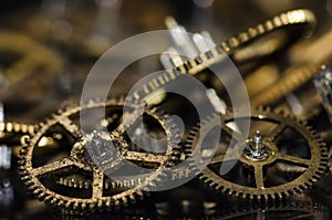 Dirty and Grimy Vintage Metallic Watch Gears on a Black Surface