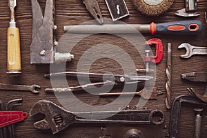 Dirty grungy set of hand tools on a wooden panel, Flat lay, Pliers screwdriver wrench rusted iron metal