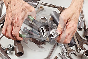 Dirty hand of serviceman with wrench to tighten the nut