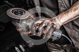 Dirty hands with angle grinder