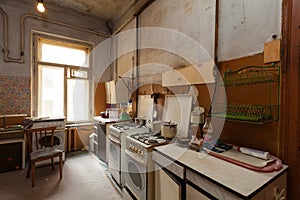 Dirty kitchen with furniture and gas stoves is in the apartment for temporary living existence refugees who were forced to mig