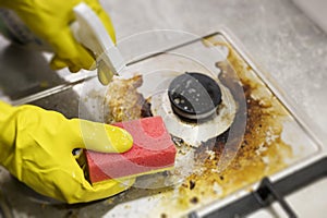 dirty kitchen stove, empty and full bottles of detergents around.