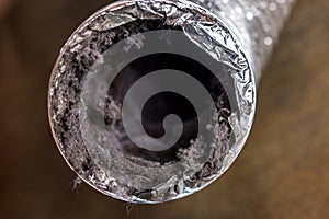 A dirty laundry flexible aluminum dryer vent duct ductwork filled with lint, dust and dirt