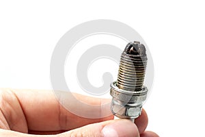 Dirty Lean Spark Plug. Auto mechanic holds an old spark plug on white background