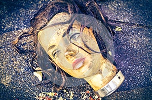 Dirty mannequin doll head was left in a garbage dump