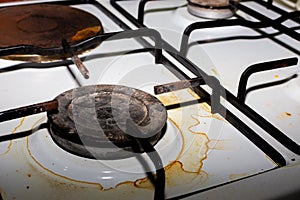 Dirty metal plate. The burners of the combined electric and gas hob are covered with dirt and grease after cooking