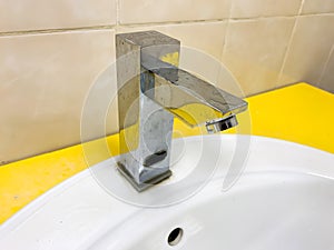 A dirty modern faucet, water tap with limescale on a water bowl, basin in bathroom at home