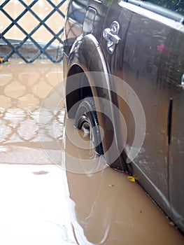 Dirty muddy dirt and toxic water flood after heavy rain in urban zone destroy a family car