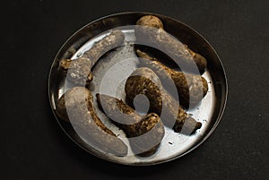 Dirty mushroom in a plate on a black background