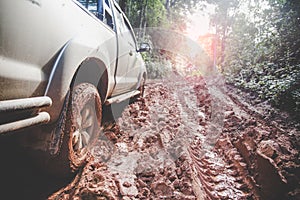 Dirty offroad car, SUV covered with mud on countryside road, Off-road tires,  offroad travel  and driving concept