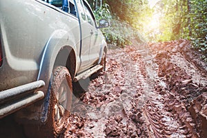 Dirty offroad car, SUV covered with mud on countryside road, Off-road tires,  offroad travel  and driving concept