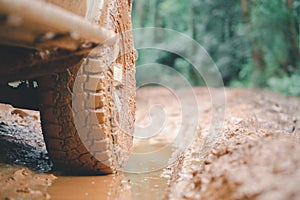 Dirty offroad car, SUV covered with mud on countryside road, Off-road tires,  offroad travel  and driving concept