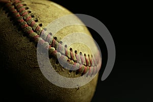 Dirty, old baseball on a black background.