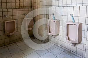 Dirty old bathroom,Interior Public toilet urinals in men toilet bowl is not very clean