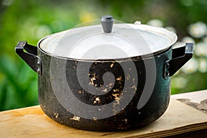 A dirty old metal pot. Close-up photo