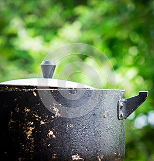 A dirty old metal pot. Close-up photo
