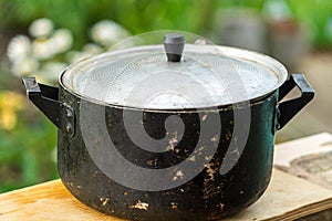 A dirty old metal pot. Close-up photo