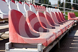 Dirty old red seats in an open-air sports stadium