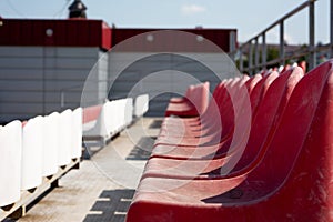 Dirty old red seats in an open-air sports stadium