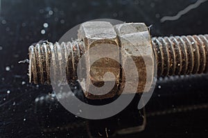 Dirty Old Rusty Bolt and Nut on a Black Surface.