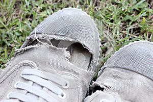 Dirty old shoes on grass background, still life style