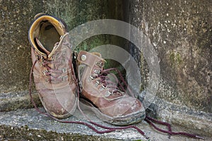 Dirty old shoes on grunge background.